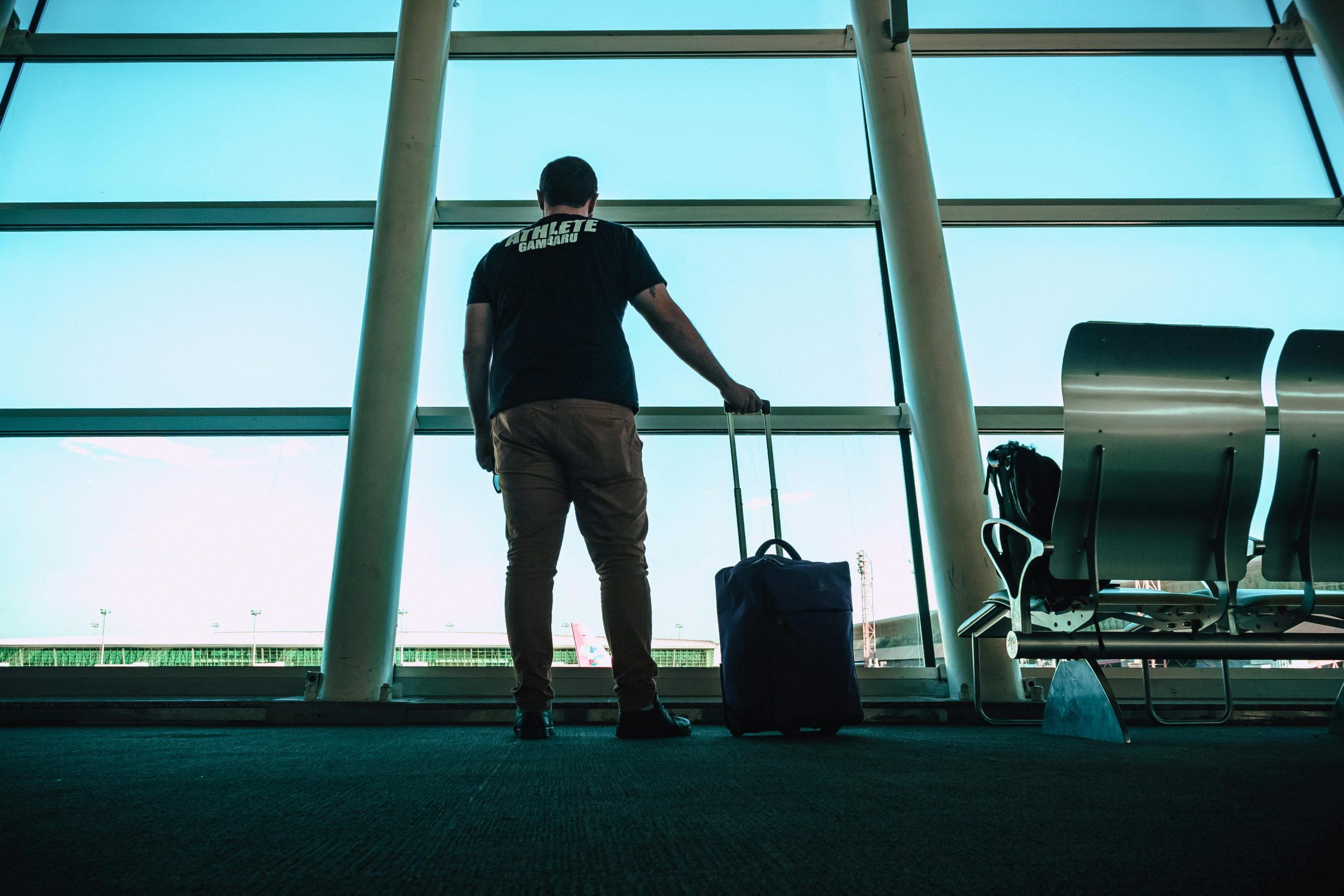 Man standing in an airport with luggage
